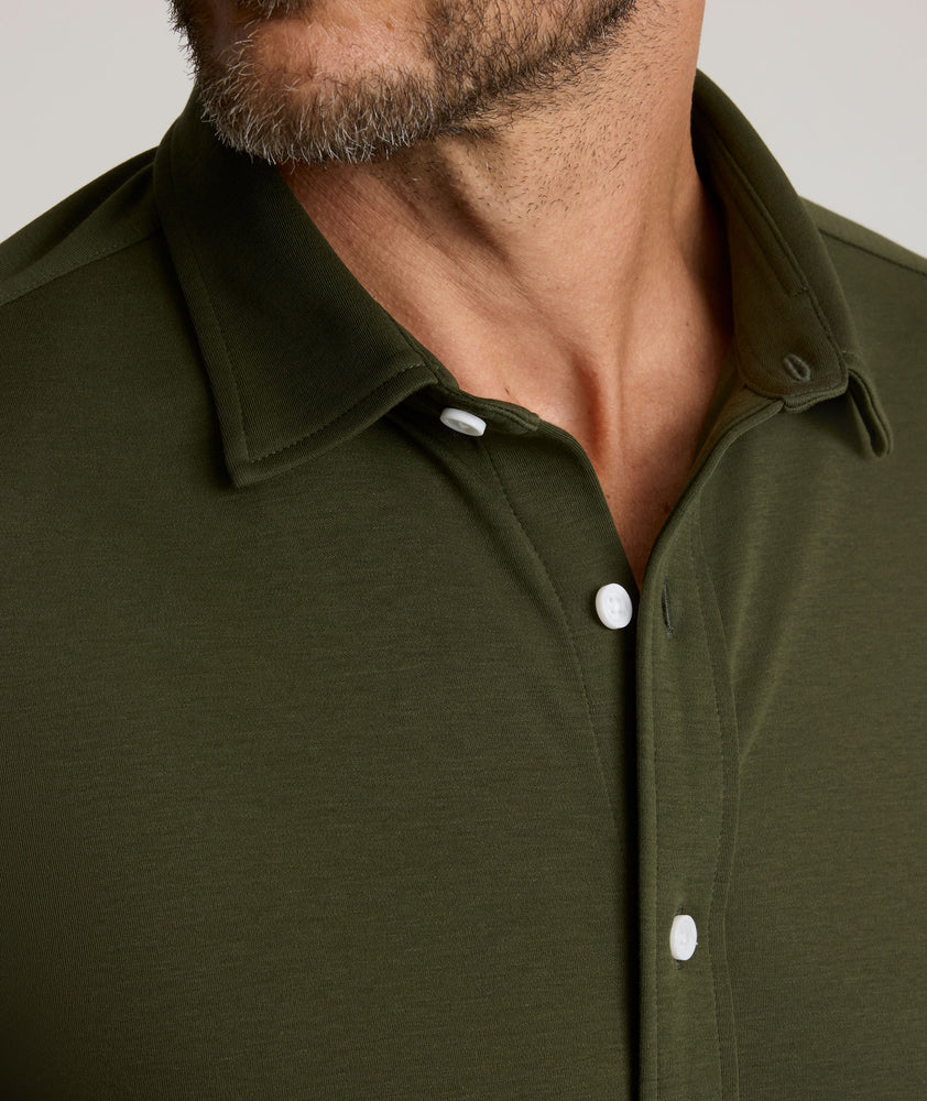 Model is wearing UNTUCKit Sullivan wrinkle-free knit shirt in forest green. 