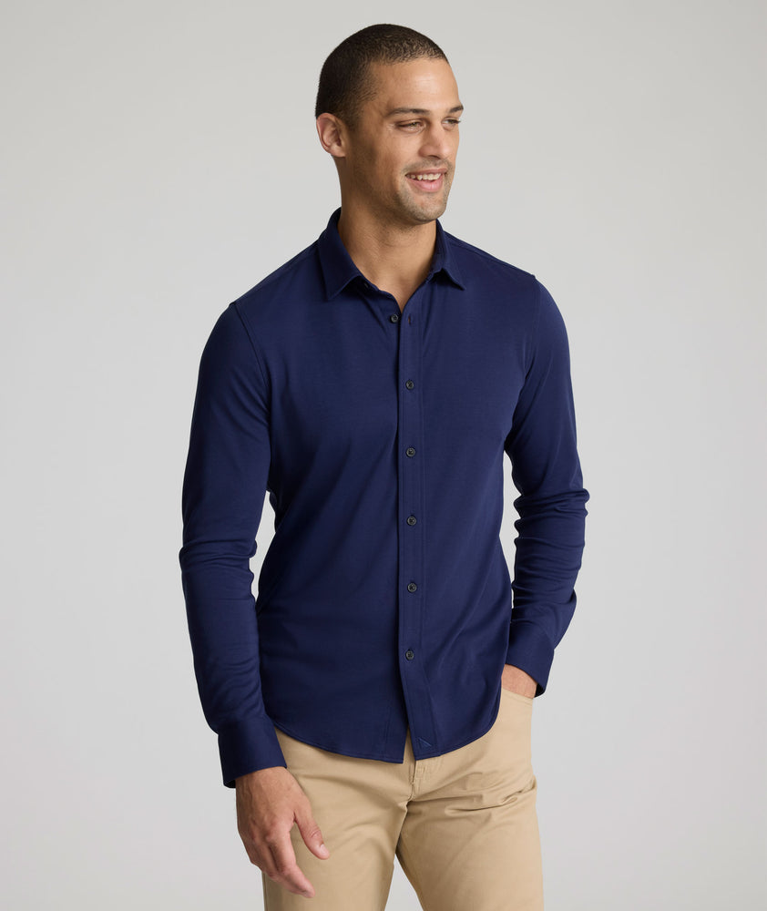 Model is wearing UNTUCKit Sullivan wrinkle-free knit shirt in navy. 