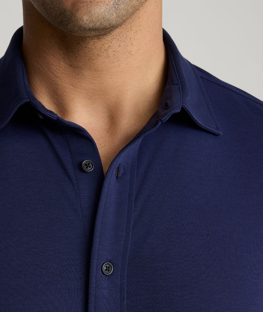 Model is wearing UNTUCKit Sullivan wrinkle-free knit shirt in navy. 
