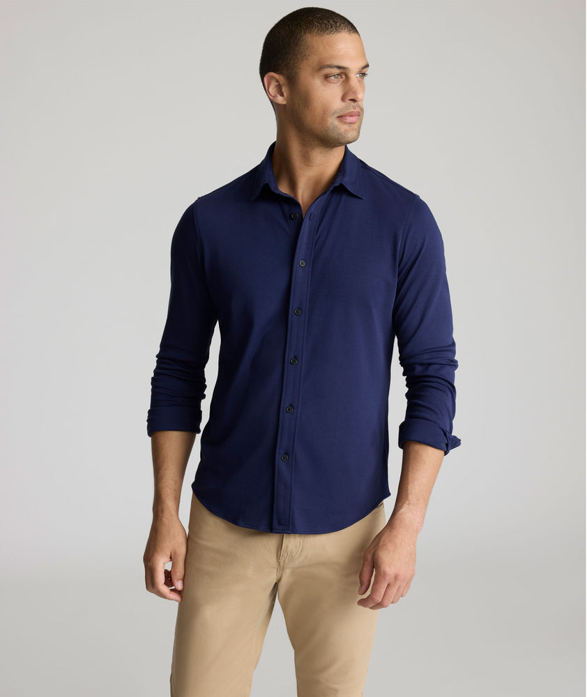 Model is wearing UNTUCKit Sullivan wrinkle-free knit shirt in navy. 