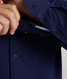 Model is wearing UNTUCKit Sullivan wrinkle-free knit shirt in navy. 