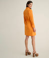 Model is wearing UNTUCKit Taylor dress in orange. 