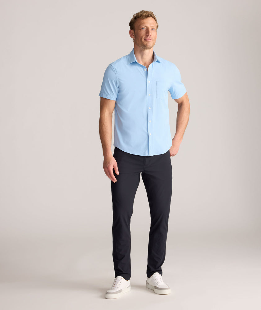 Model is wearing UNTUCKit Torre 5-Pocket Tech Pant in Black. 