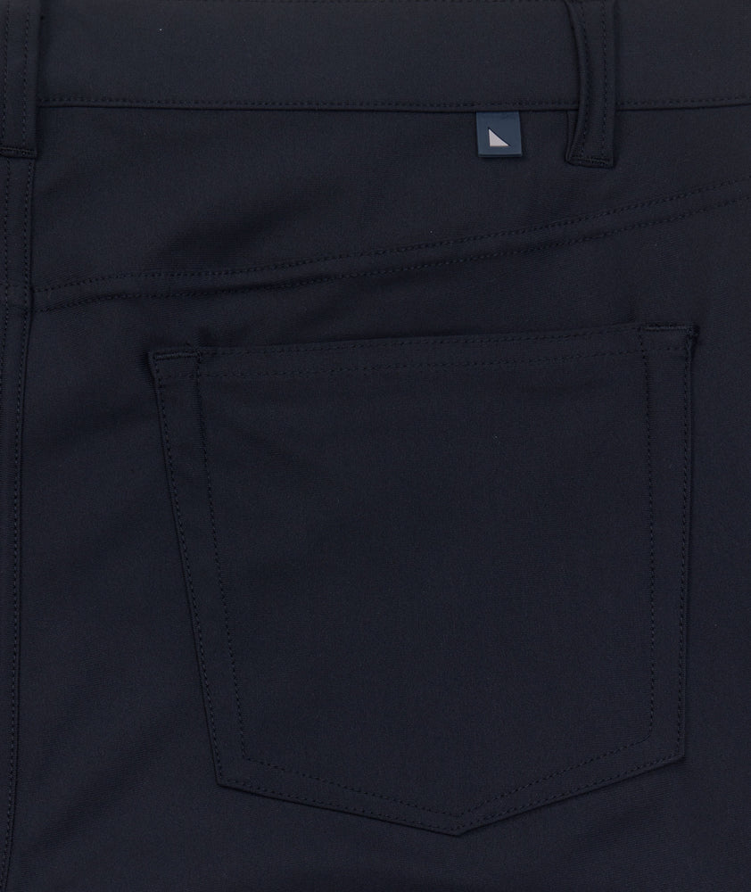 Model is wearing UNTUCKit Torre 5-Pocket Tech Pant in Black. 