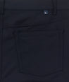 Model is wearing UNTUCKit Torre 5-Pocket Tech Pant in Black. 