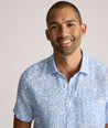 Model is wearing UNTUCKit Turner short sleeve linen shirt in light blue print. 
