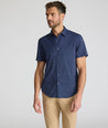 Model is wearing UNTUCKit Performance Short-Sleeve Vandelay Shirt in Navy Medallion Print.