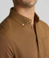 Model is wearing UNTUCKit Classic Cotton Long-Sleeve Polo in brown. 