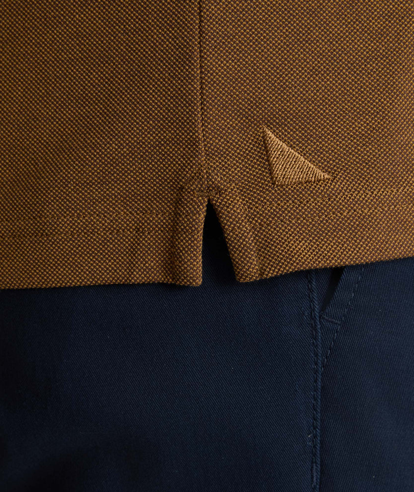 Model is wearing UNTUCKit Classic Cotton Long-Sleeve Polo in brown. 