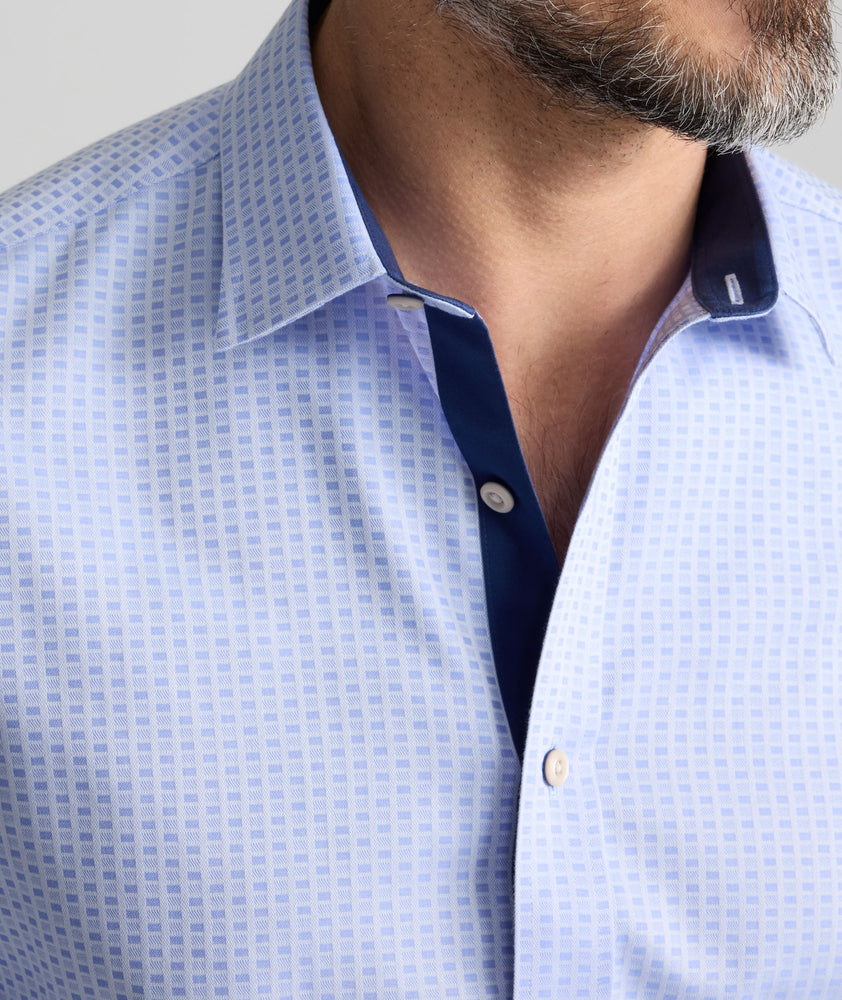 Model is wearing UNTUCKit wainwright shirt in blue.