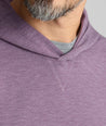 Close-up of a man wearing a heathered purple pullover hoodie with a gray crew-neck undershirt, showing the collar and chest area.