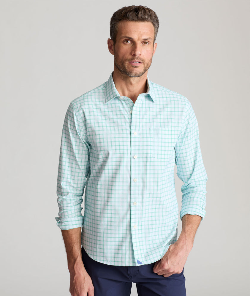Model is wearing UNTUCKit Wells in light blue and green check. 