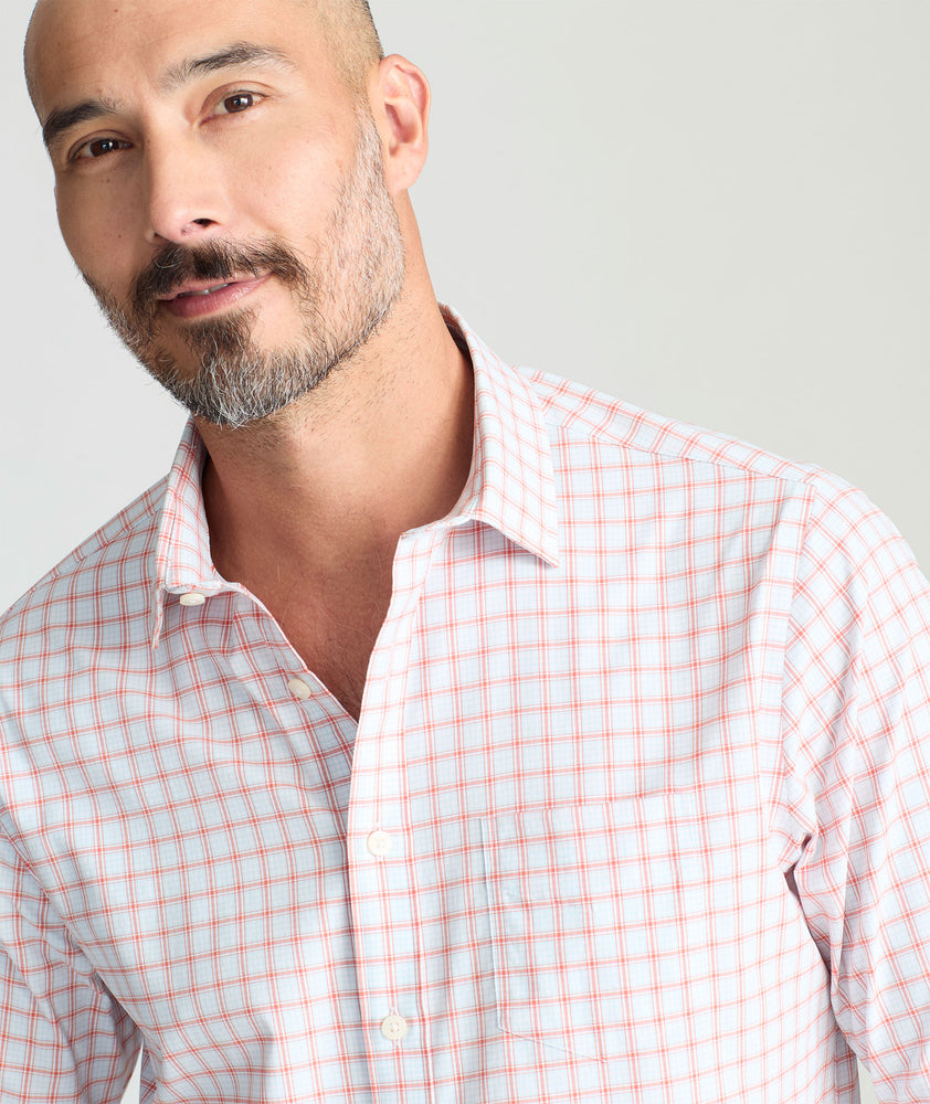 Model is wearing UNTUCKit Wells performance shirt in light blue and orange check. 