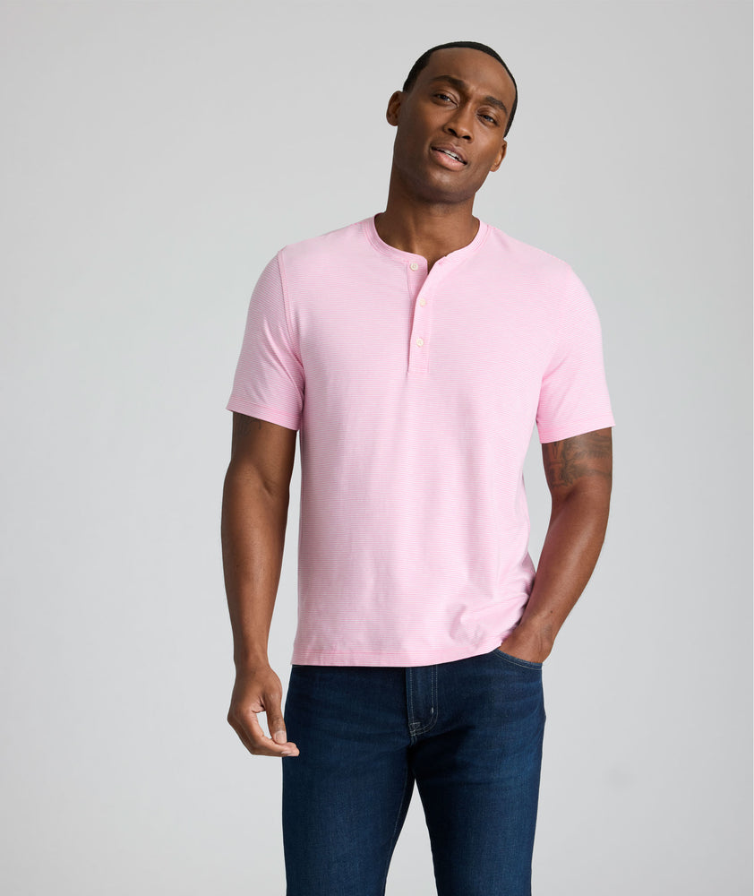 Model is wearing UNTUCKit westray henley in stripe pink. 