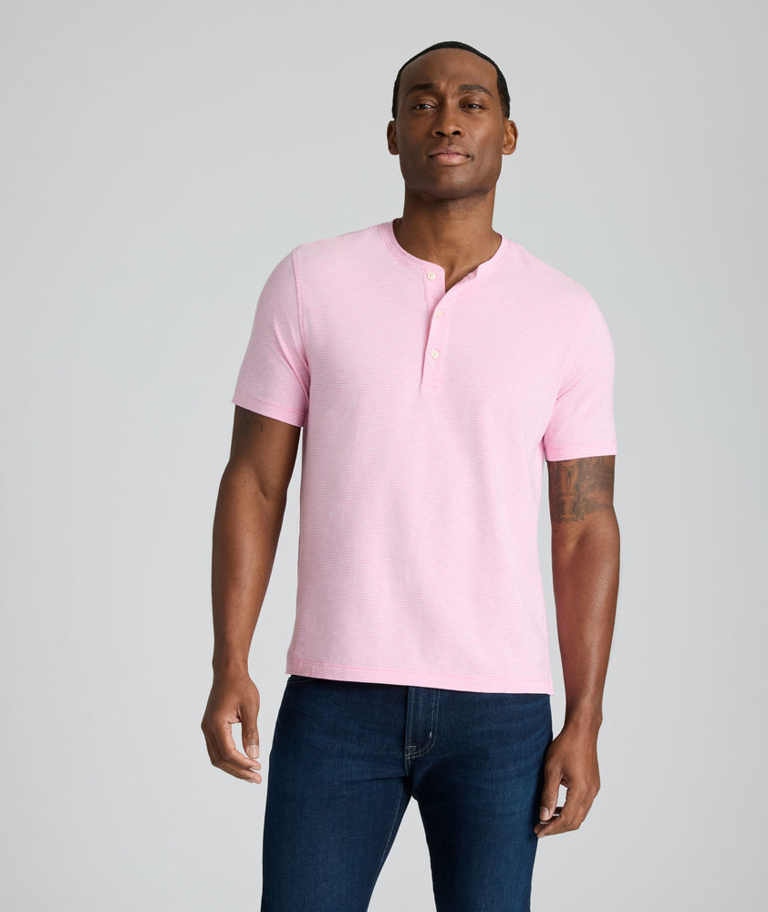 Model is wearing UNTUCKit westray henley in stripe pink. 