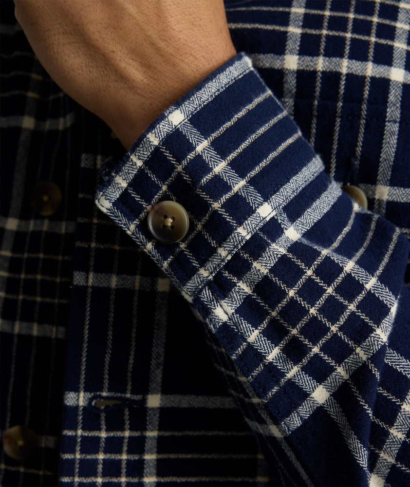 Model is wearing UNTUCKit Whitaker plaid over shirt in navy. 