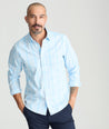 Model is wearing UNTUCKit yates wrinkle-free shirt in light blue large plaid. 