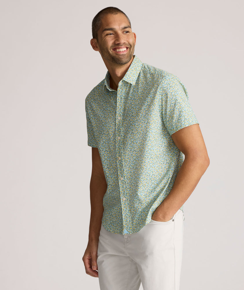 Model is wearing UNTUCKit Yorke performance short sleeve green and yellow floral print shirt. 
