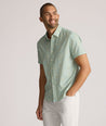 Model is wearing UNTUCKit Yorke performance short sleeve green and yellow floral print shirt. 
