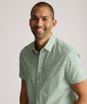 Model is wearing UNTUCKit Yorke performance short sleeve green and yellow floral print shirt. 