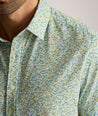 Model is wearing UNTUCKit Yorke performance short sleeve green and yellow floral print shirt. 