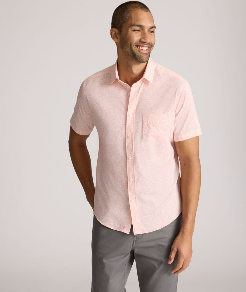 Model is wearing UNTUCKit zeller performance short sleeve shirt in pink geo. 