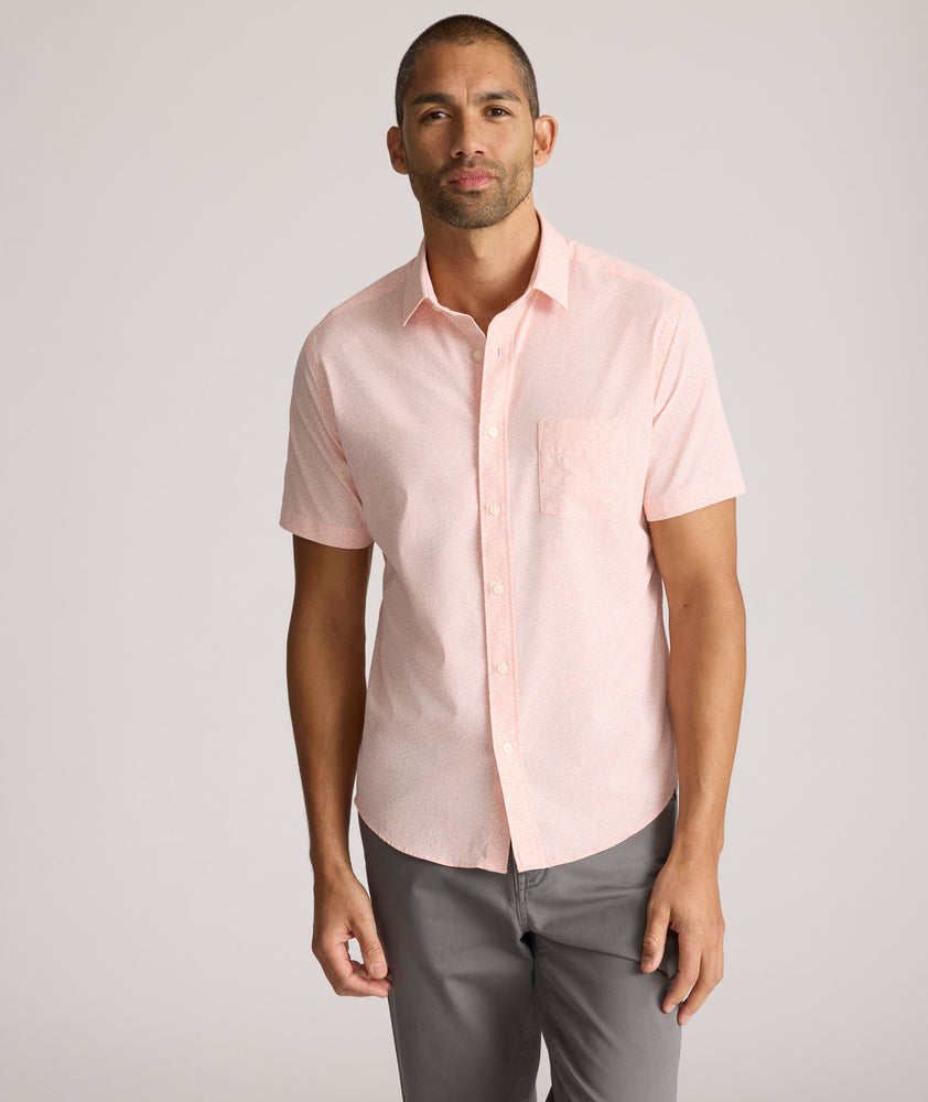 Model is wearing UNTUCKit zeller performance short sleeve shirt in pink geo. 