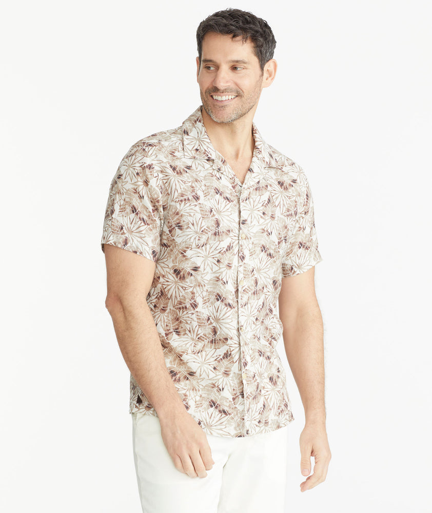 Model is wearing an UNTUCKit Tan Leaf Print Linen Short-Sleeve Aidani Shirt