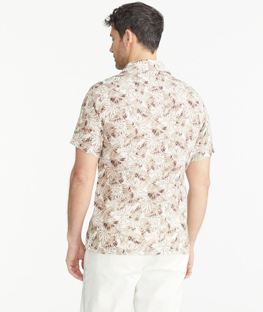 Model is wearing an UNTUCKit Tan Leaf Print Linen Short-Sleeve Aidani Shirt