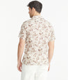 Model is wearing an UNTUCKit Tan Leaf Print Linen Short-Sleeve Aidani Shirt