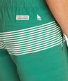 Model wearing UNTUCKit Green 7-Inch Recycled Swim Trunks