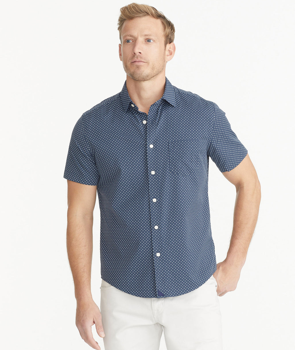Model is wearing UNTUCKit Navy Polka Dot Print Wrinkle-Free Performance Short-Sleeve Brenner Shirt.
