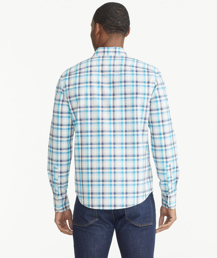 Model is wearing UNTUCKit Teal Navy & White Check Wrinkle-Free Graciano Shirt.