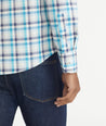 Model is wearing UNTUCKit Teal Navy & White Check Wrinkle-Free Graciano Shirt.