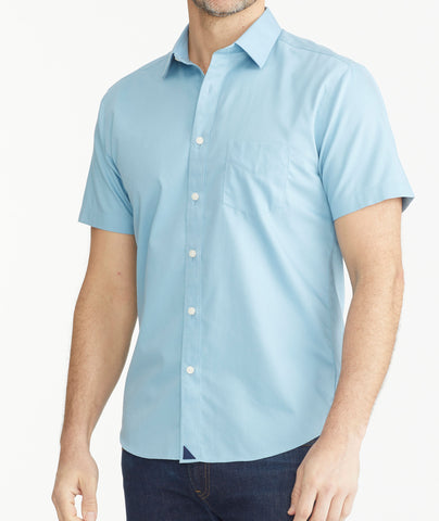 Model is wearing UNTUCKit Light Blue Denim Wrinkle-Free Short-Sleeve Hargrove Shirt.