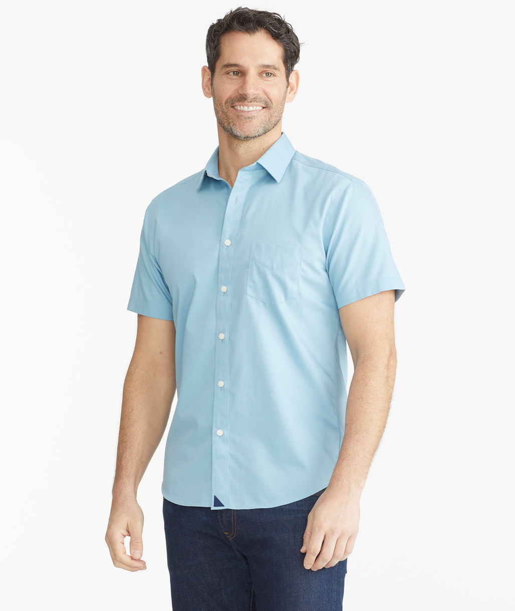 Model is wearing UNTUCKit Light Blue Denim Wrinkle-Free Short-Sleeve Hargrove Shirt.