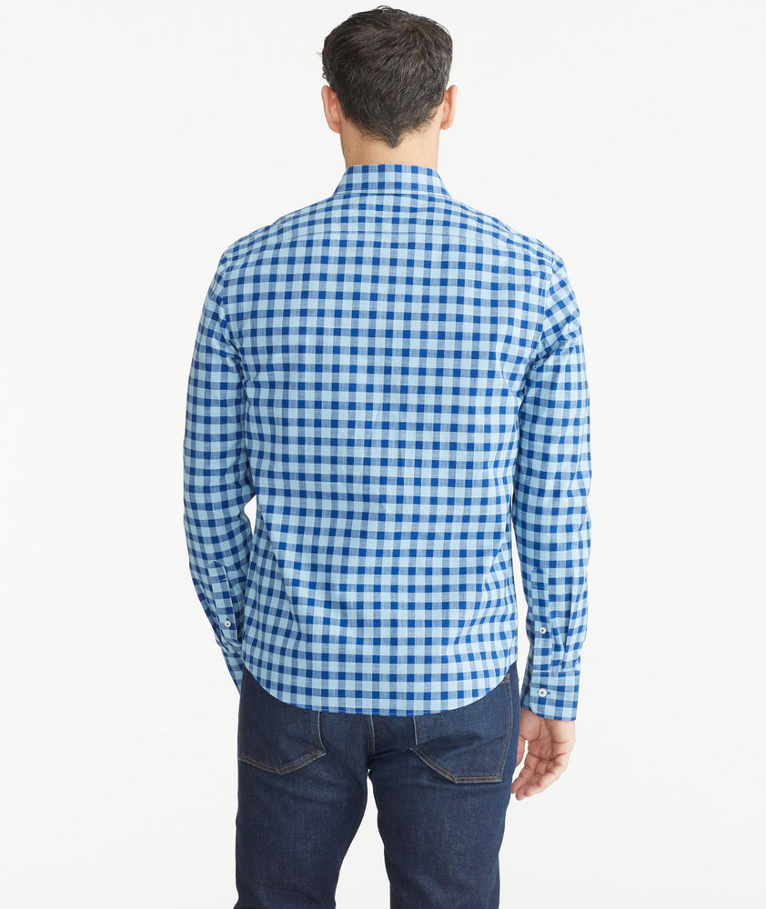 Model is wearing UNTUCKit Light Blue & Navy Gingham Wrinkle-Free Mariano Shirt.