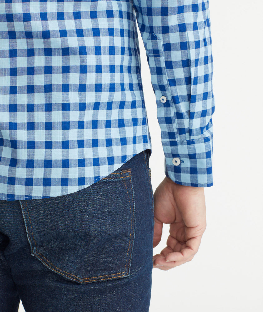 Model is wearing UNTUCKit Light Blue & Navy Gingham Wrinkle-Free Mariano Shirt.