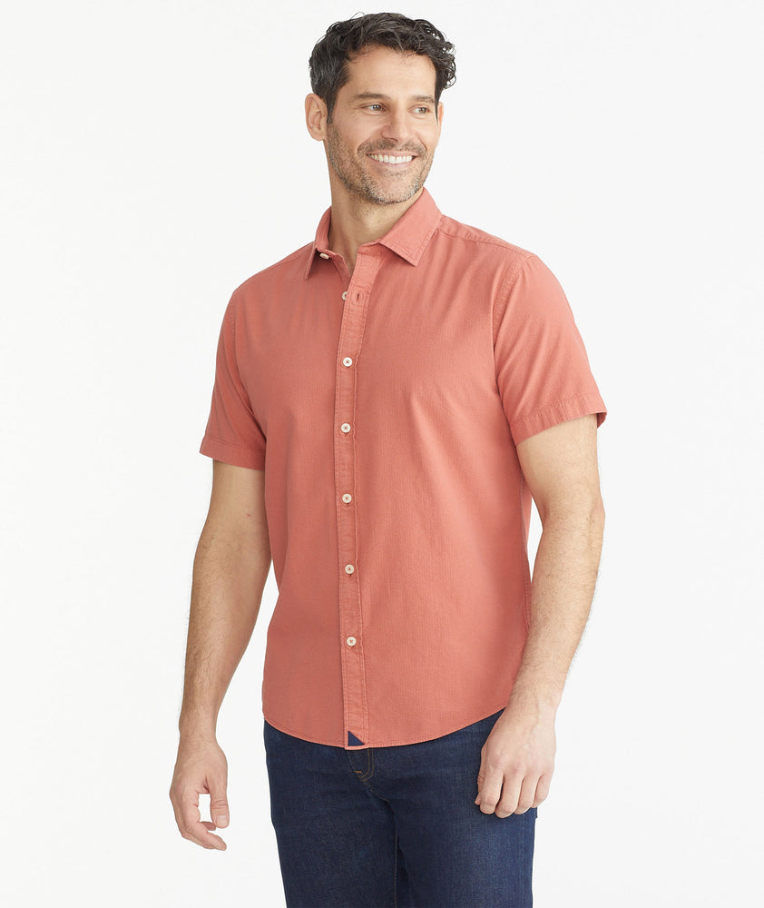 Model is wearing UNTUCKit Dark Orange Cotton Seersucker Short-Sleeve Pavao Shirt.