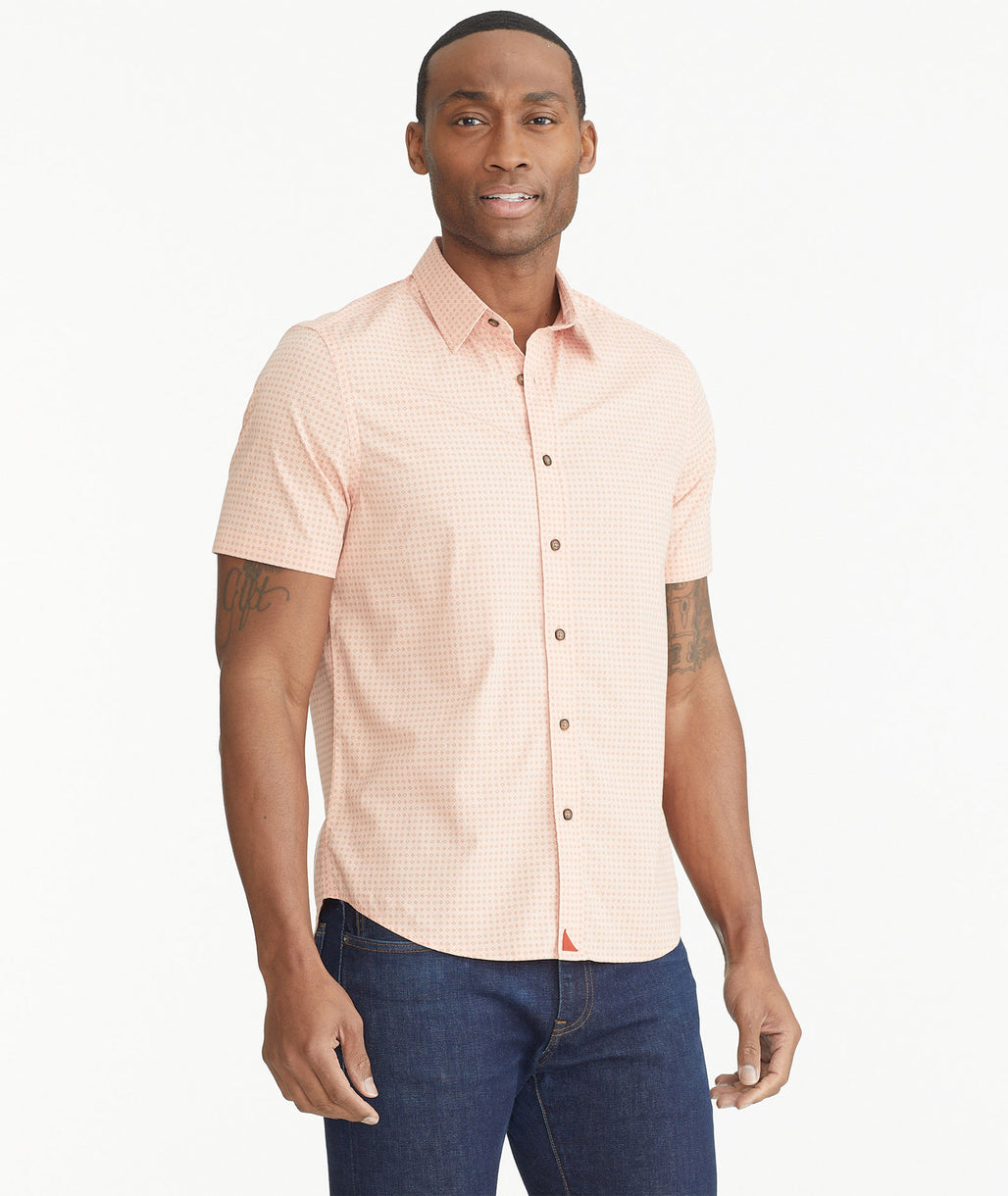 Model is wearing UNTUCKit Peach Geo Prink Cotton Short-Sleeve Dot Shirt.
